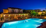 Stimmungsvolle Abendaufnahme mit beleuchtetem Pool und gemütlicher Barterrasse – ideal für entspannte Urlaubsmomente unter dem Sternenhimmel.
