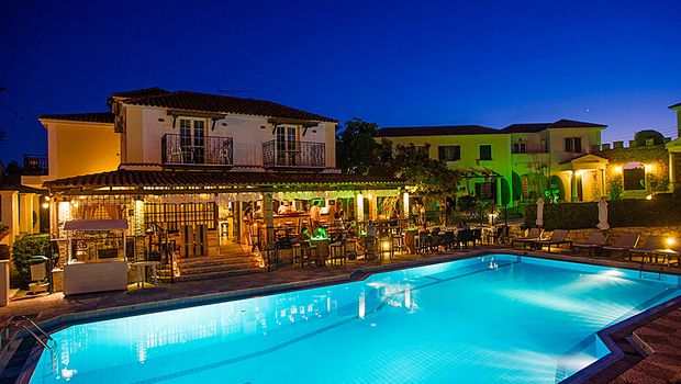 Stimmungsvolle Abendaufnahme mit beleuchtetem Pool und gemütlicher Barterrasse – ideal für entspannte Urlaubsmomente unter dem Sternenhimmel.
