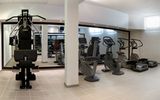 Heller Fitnessraum mit modernen Cardiogeräten, Kraftstation und großen Spiegeln – ideal für sportlich aktive Urlaubsgäste.