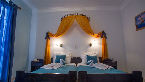 Gemütliches Zimmer mit liebevollen Details, farbenfrohem Baldachin und dekorativ gefalteten Handtüchern – ideal für einen charmanten Aufenthalt in familiärer Atmosphäre.