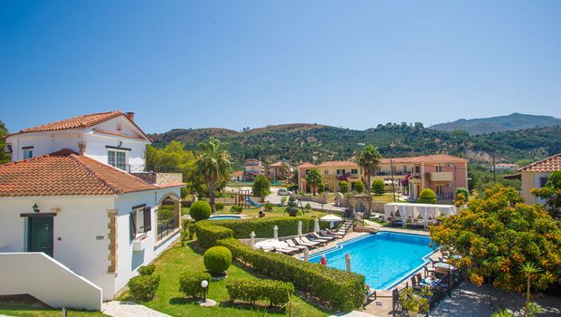 Charmante Hotelanlage inmitten grüner Hügel mit gepflegtem Garten, mediterraner Architektur und einladendem Poolbereich – ideal für entspannte Urlaubstage in idyllischer Umgebung.