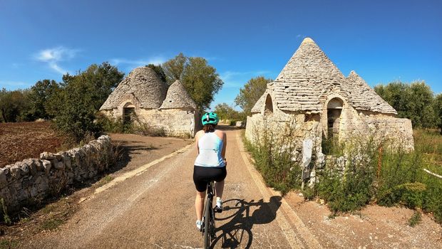Radfahrerin bei Trulli-Häusern in Apulien