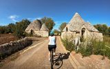 Radfahrerin bei Trulli-Häusern in Apulien